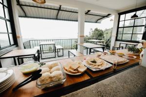 a table with sandwiches and other food on it at O'Neill's Cottage in Dikkapitiya