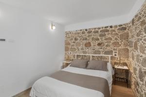 a bedroom with a bed and a stone wall at El Blanquizal A in La Aldea de San Nicolas