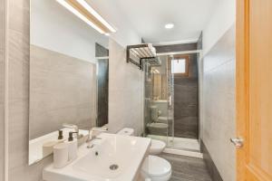 a white bathroom with a sink and a toilet at El Blanquizal A in La Aldea de San Nicolas +14 photos