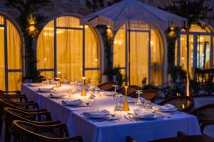a long table with white plates and wine glasses at Iconic Mediterranean Hotel in Dhërmi