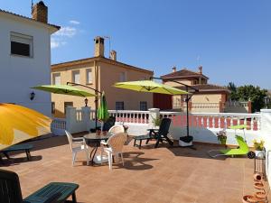a patio with chairs and tables and umbrellas at The terraces in Bácor
