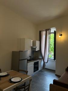 a small kitchen with a table and a dining room at Trasimeno Vacanze in Passignano sul Trasimeno