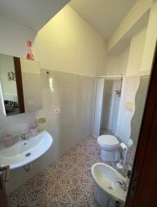 a bathroom with a white sink and a toilet at Adele Garden in Taormina