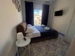 a small bedroom with a bed and a window at Adele Garden in Taormina