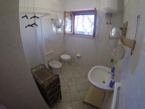 bagno bianco con lavandino e servizi igienici di Villa Punta Lunga a Favignana