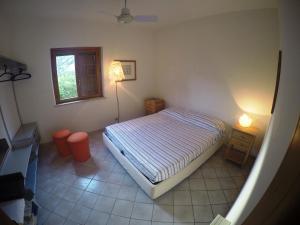 Un dormitorio con una cama y una lámpara. en Villa Punta Lunga en Favignana