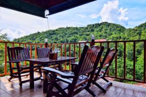 a table and chairs on a deck with a view of a mountain at ปิล๊อกพอเพลิน-pilokporploen in Ban Pilok Khi
