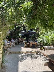 a group of people sitting at tables in a garden at L'Heure Bleue in Villeneuve-lès-Avignon
