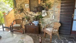 a patio with two chairs and a table with plants at B&B Il Casale Del Ginepro in Migliano