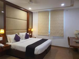 Un dormitorio con una cama y un escritorio y una ventana. en Hotel Park View, en Khajurāho