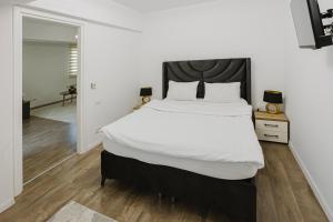 a bedroom with a large bed with a black headboard at City Center Accommodation 211 in Reşiţa