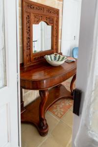 ein Holztisch mit einem Spiegel und einer Schüssel darauf in der Unterkunft Le Stanze del Monsignore in Novoli