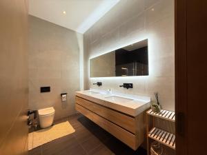 a bathroom with a sink and a toilet and a mirror at R&R Homes in Kwedonu +37 photos