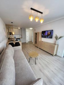 a living room with a couch and a table at Centrum Park Komfort in Kołobrzeg