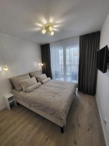 a bedroom with a bed and a ceiling fan at Centrum Park Komfort in Kołobrzeg