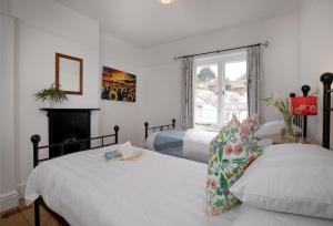 a bedroom with two beds and a fireplace and a window at Withycombe in Seaton