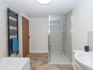 a white bathroom with a shower and a sink at Aunty Junes Cottage in Okehampton +37 photos