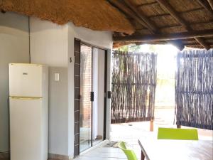 a kitchen with a refrigerator and a table and chairs at Phomola Guesthouse in Brits