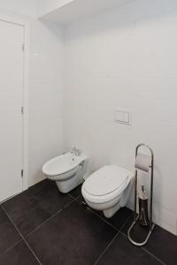 a white bathroom with a toilet and a bidet at City Center Accommodation - 410 in Reşiţa