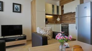 a kitchen with a dining table and a refrigerator at Апартаменти Сънбрийз - Sunbreeze Apartments in Byala
