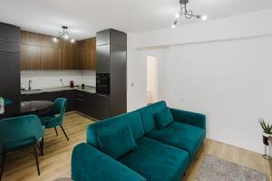 a living room with a blue couch and a kitchen at City Center Accommodation - 410 in Reşiţa