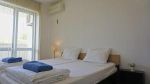 a bedroom with two beds with towels on them at Апартаменти Сънбрийз - Sunbreeze Apartments in Byala +79 photos