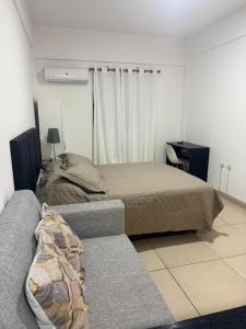 Un dormitorio con una cama y un sofá. en Apartamento, en San Lorenzo