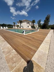 a swimming pool on top of a wooden deck at Domaine de LA GRIME in Lias
