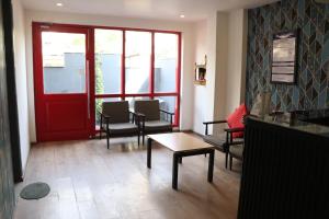 a waiting room with a red door and chairs at TIPSYY INN 003 in Gurgaon