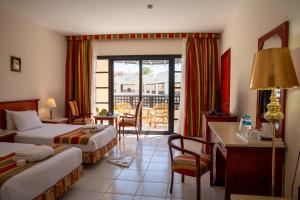 Una habitación de hotel con dos camas y balcón. en Blend Club Aqua Resort, en Hurghada 96 fotos más