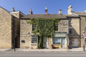 an old brick building with ivy growing on it at Flat 2 Martins House in Stow on the Wold