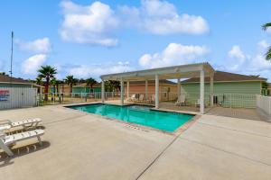 Una piscina con sillas y un edificio. en Oasis Dream #193, en Rockport
