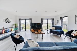 ein Wohnzimmer mit einem blauen Sofa und Stühlen in der Unterkunft Acorn House in Dorchester