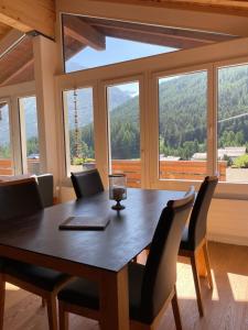 a dining room with a table and chairs and a large window at Saaserhof Apartments in Saas-Fee