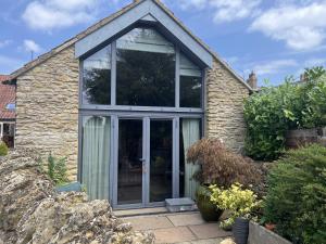 an extension to a stone house with a glass door at The Nail Shed in Scarborough