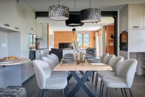 Una cocina y un comedor con mesa y sillas. en Cluzel Alpine Loft - OVO Network, en La Clusaz