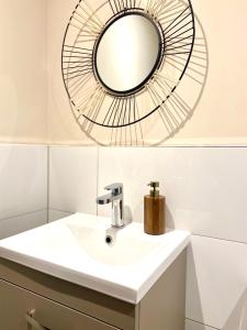 a bathroom with a sink and a mirror at Safari 2 Bedroom Condo with Free Secure Parking in Manchester
