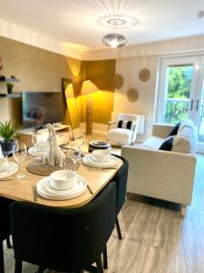 a dining room table with chairs and a living room at Safari 2 Bedroom Condo with Free Secure Parking in Manchester