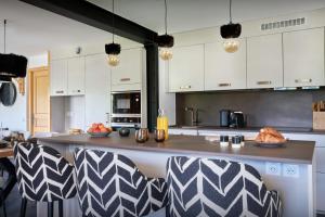 una cocina con una gran encimera con sillas. en Cluzel Alpine Loft - OVO Network, en La Clusaz