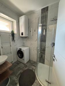 a bathroom with a shower and a washing machine at Sonas in the city center in Karlovac