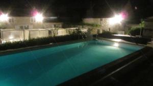 a large swimming pool at night with street lights at La Fromagerie in Mondion