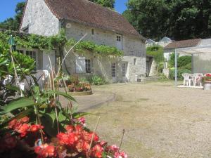 a stone house with flowers in front of it at La Fromagerie in Mondion