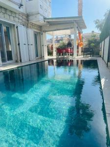 a swimming pool with blue water in a house at Evalacati - Villa Palma-Tamamen Müstakil Villa in Cesme