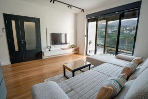 Apartman VISTA FIUME في تريبينيي: غرفة معيشة مع أريكة وتلفزيون