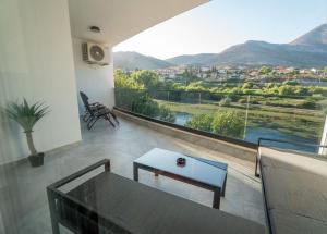 Apartman VISTA FIUME في تريبينيي: غرفة معيشة مع طاولة زجاجية ونافذة كبيرة