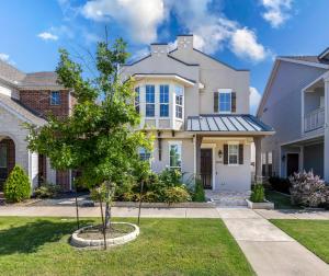 a house with a tree in the front yard at Luxe Retreat with EV Charger & Putting Green in Frisco