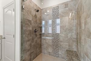 a bathroom with a shower with a glass door at Luxe Retreat with EV Charger & Putting Green in Frisco +78 photos