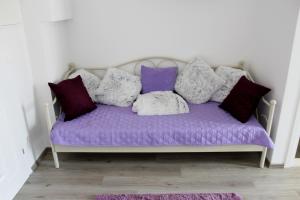 a purple couch with pillows on it in a room at Adriona apartments with parking in Makarska