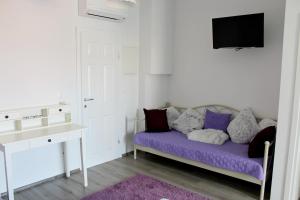 a white room with a purple couch and a tv at Adriona apartments with parking in Makarska