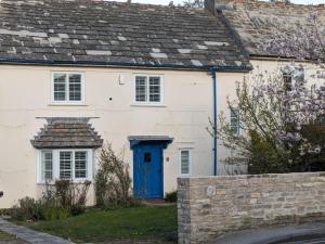 a white house with a blue door at Fig Tree Cottage - Corfe Castle in Corfe Castle
